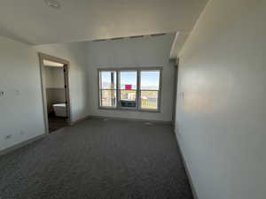 Carpeted interior space with neutral wall tones and a distinct ceiling line