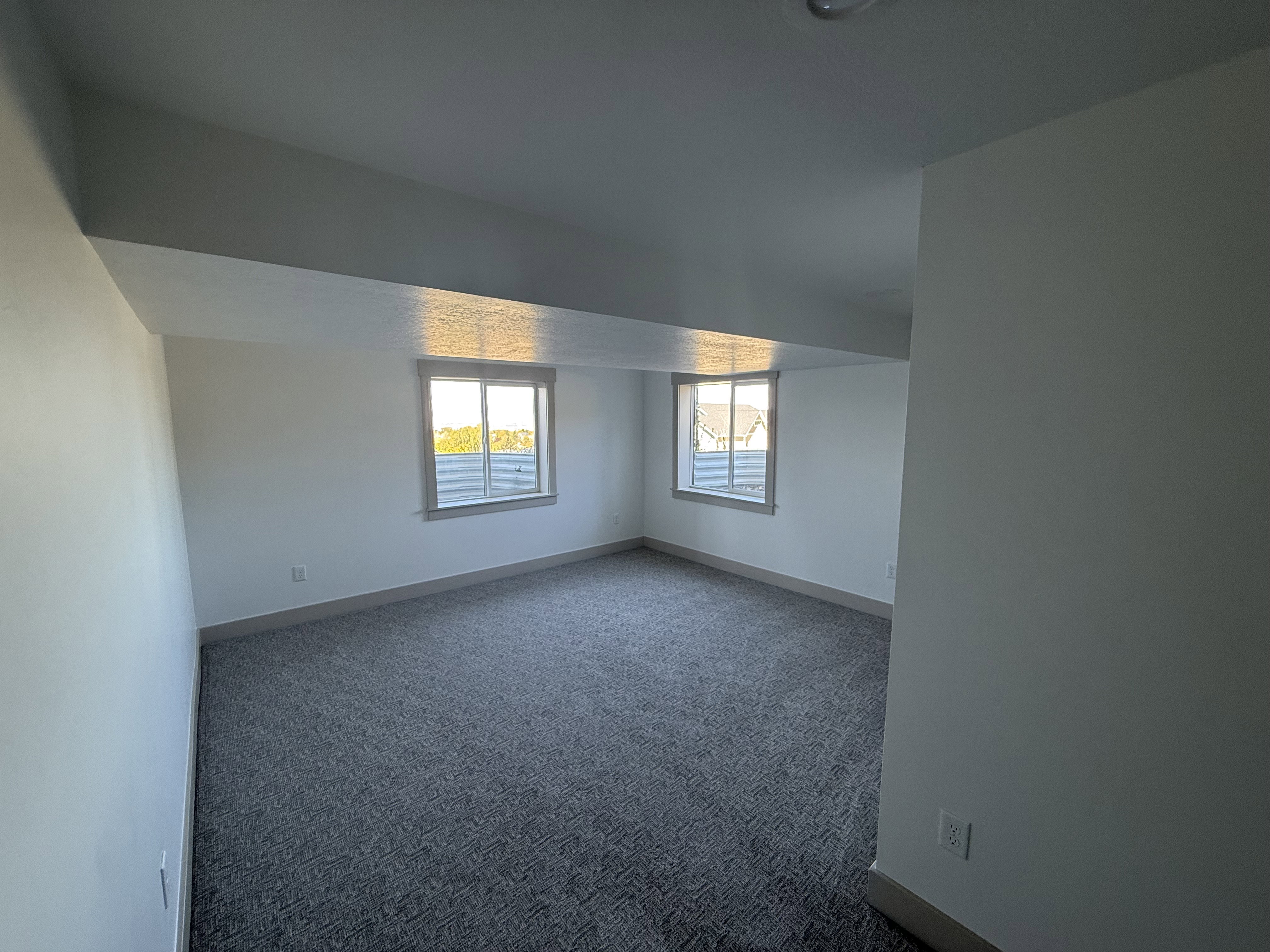 Room featuring recessed lighting, two windows with window sills, textured carpet flooring, and neutral wall tones