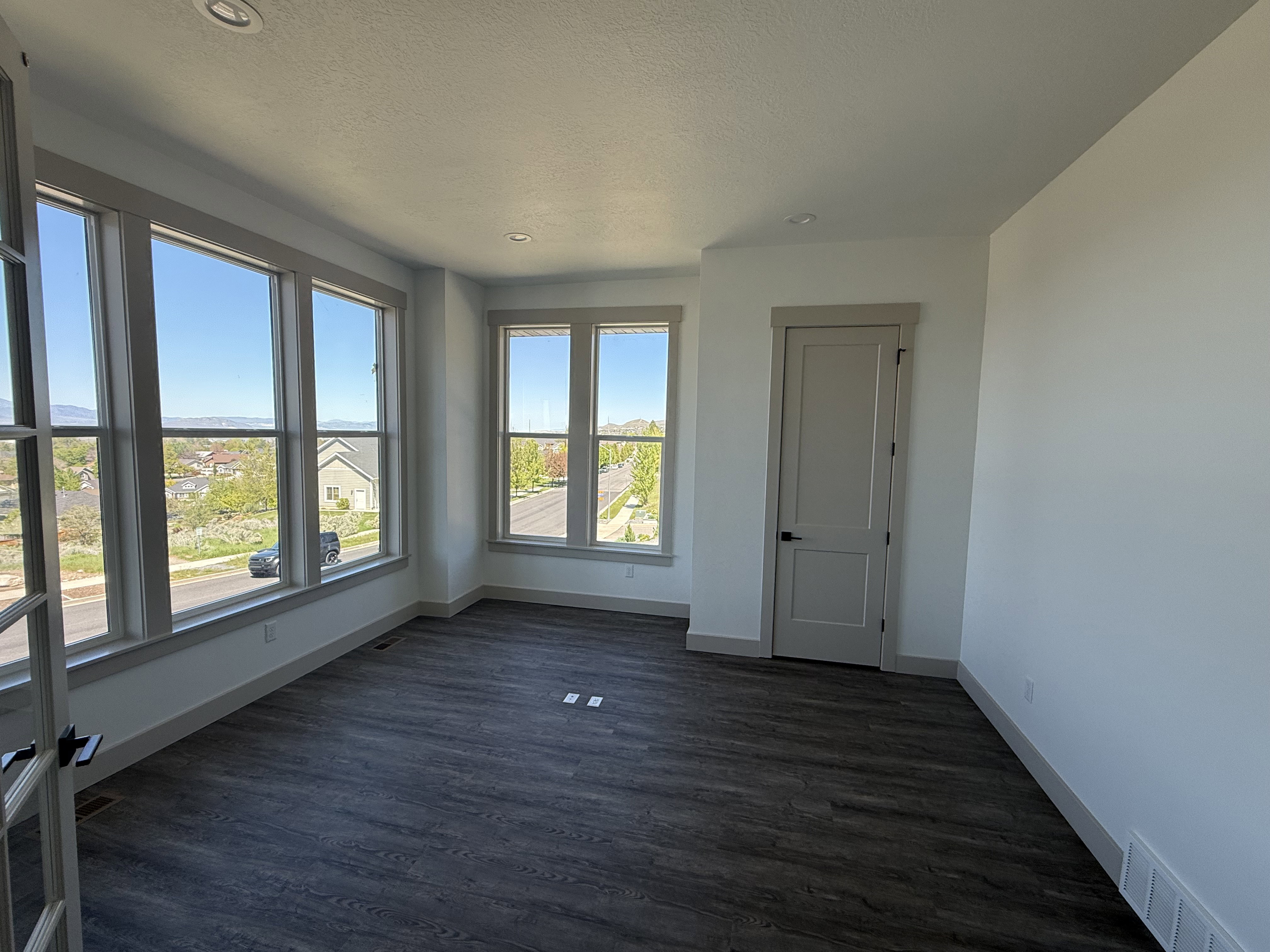 Bright interior space featuring an expansive window wall and wood-finish flooring