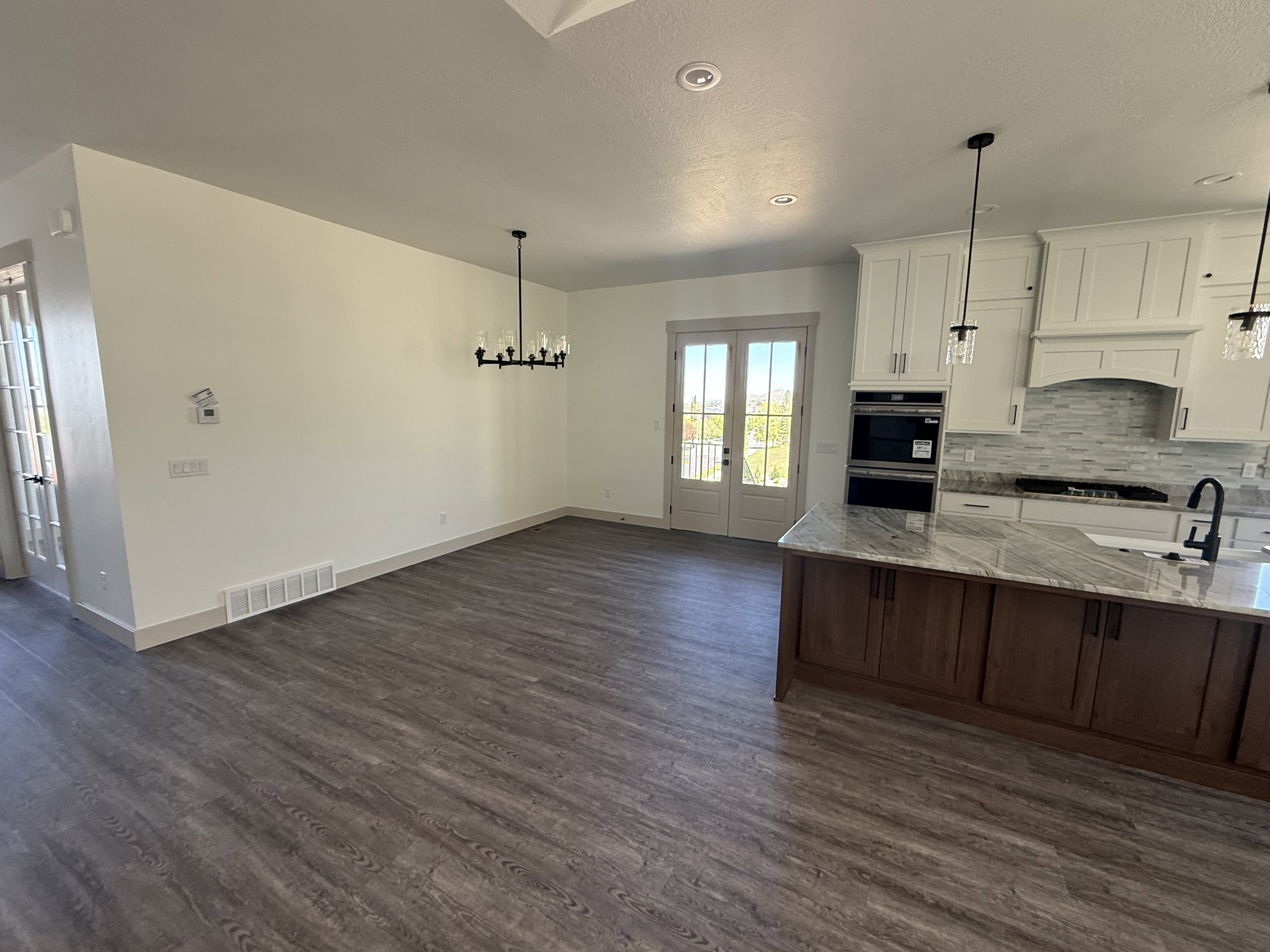 Open-concept kitchen and dining area featuring wood-finish flooring