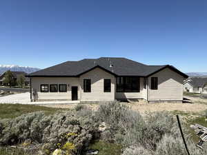 Contemporary ranch-style residence featuring horizontal siding, a dark shingle roof, and contrasting black-framed windows