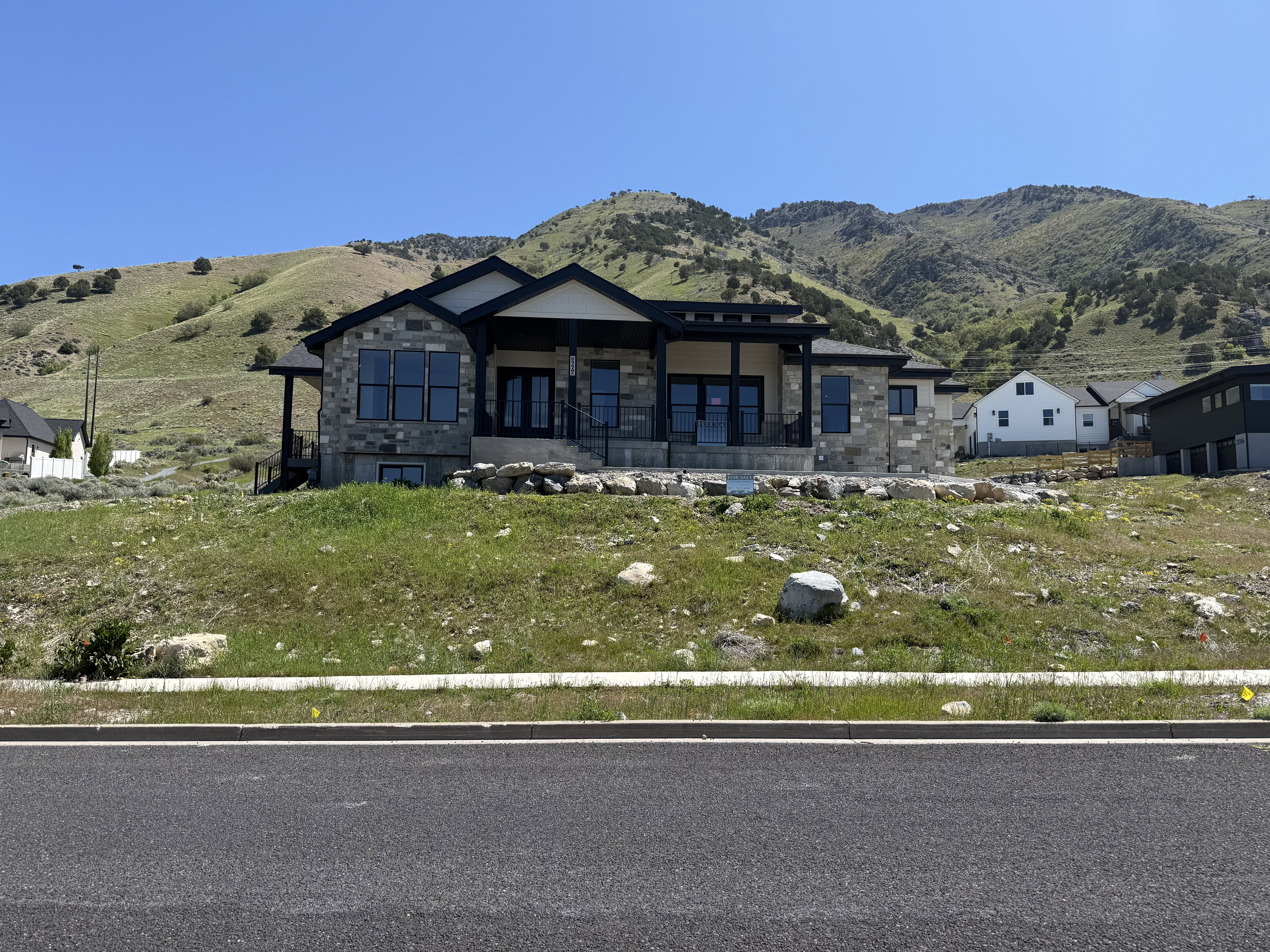 Contemporary stone and stucco facade with a covered front porch