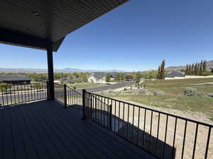 Spacious outdoor deck featuring dark composite decking, black metal railings, and an overhead soffit with recessed lighting