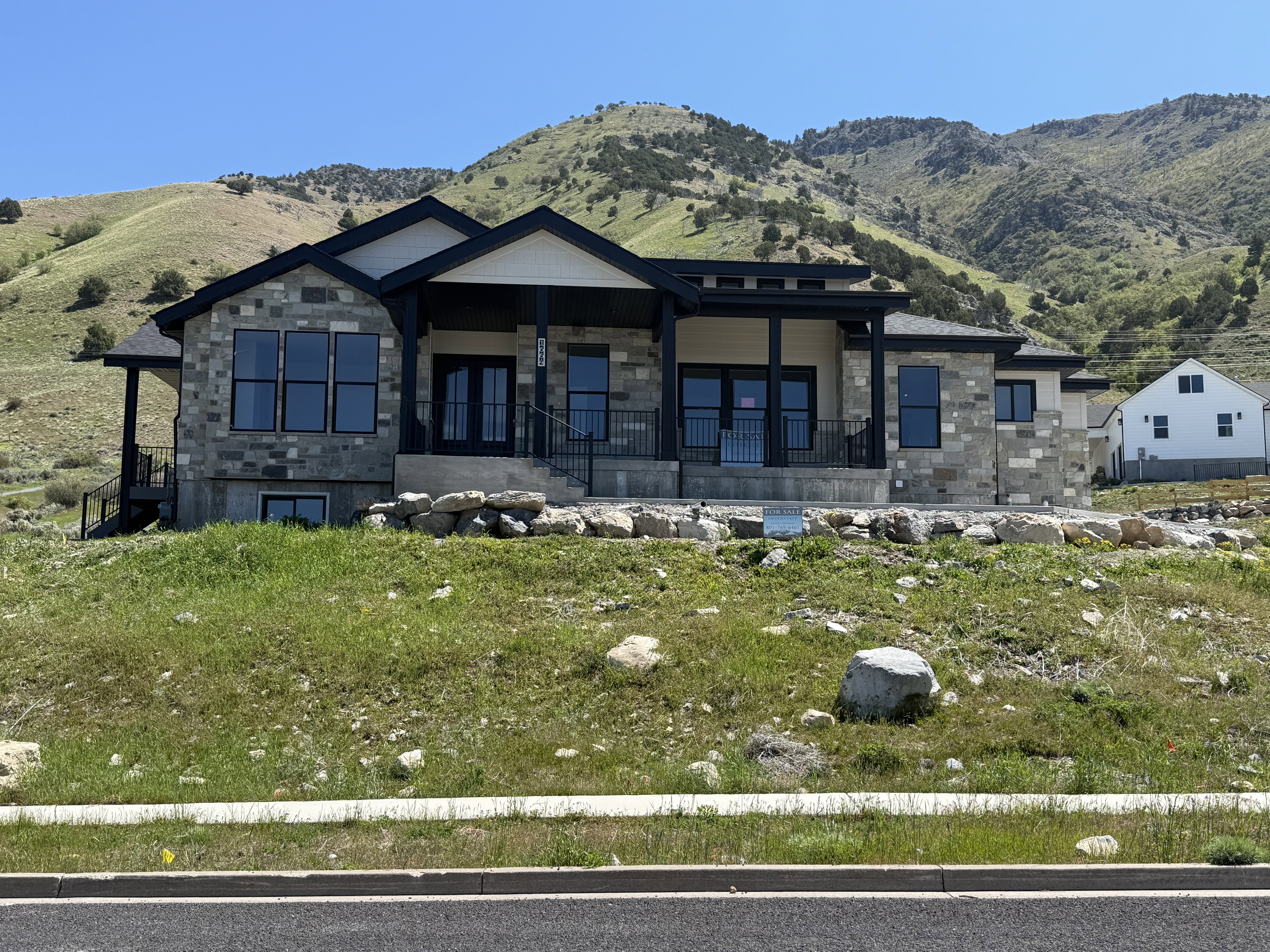 Contemporary residence featuring a stone and siding exterior with a prominent covered entry