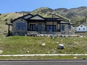 Contemporary residence featuring a stone and siding exterior with a prominent covered entry