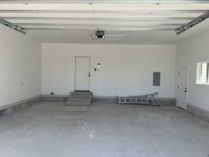 Spacious garage featuring a concrete floor, painted walls, and built-in overhead garage door track system