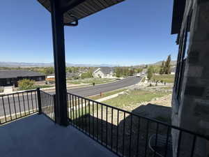 Covered concrete patio featuring black metal railings and a distant mountain backdrop