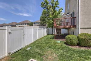 Expansive grass lawn bordered by a white privacy fence