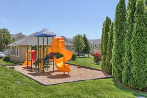 Outdoor recreational area featuring a multi-color play structure with slides and climbing elements