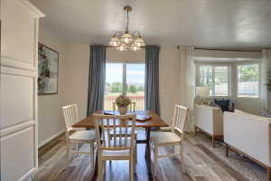 Open-concept dining area featuring wood-finish flooring and a multi-light pendant fixture