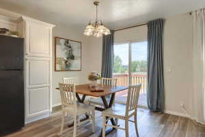 Dining area featuring wood-finish flooring and a contemporary chandelier
