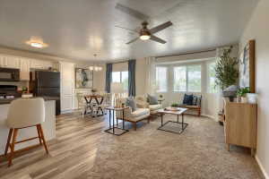 Open-concept living space featuring a bay window, recessed lighting, and a ceiling fan