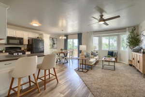 Open-concept living space with wood-finish flooring extending into the kitchen and dining areas