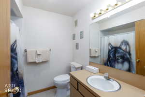 Bathroom featuring an integrated vanity sink with a laminate countertop, a large wall-mounted mirror, and a multi-bulb vanity light fixture