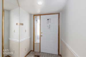 Entryway featuring a paneled door with wood trim, a textured glass sidelight, and recessed lighting