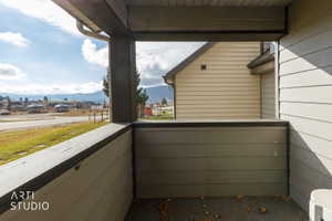 Covered outdoor space featuring a composite railing and mountain scenery