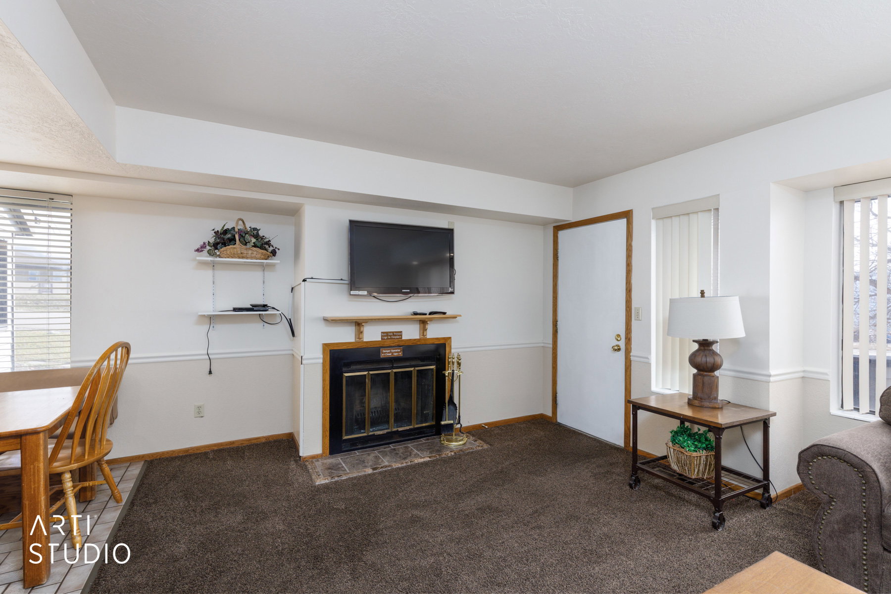 Living area featuring a fireplace with a black insert, wood mantel, and tile hearth