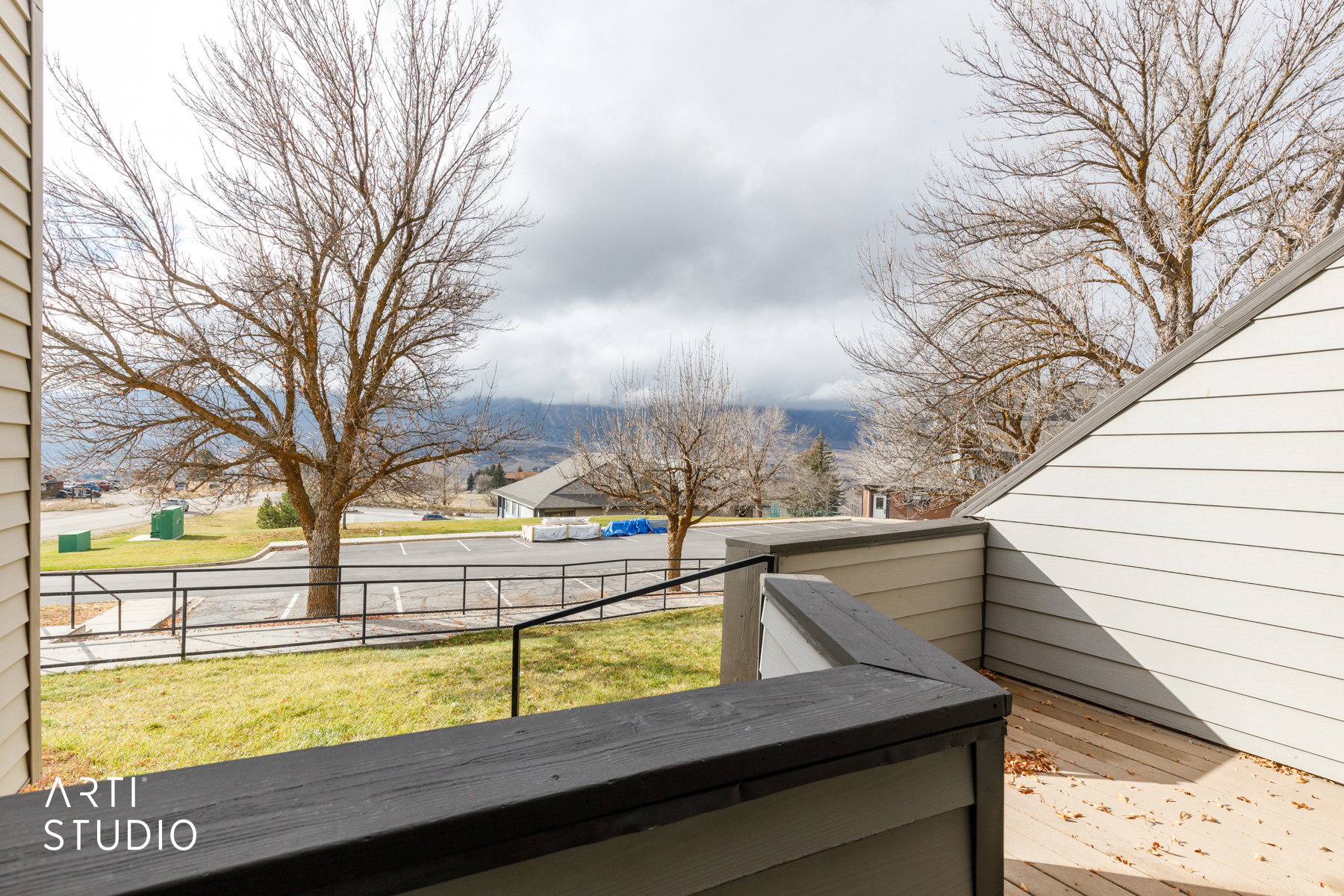 Outdoor deck featuring composite decking and railing, with a backdrop of distant mountains