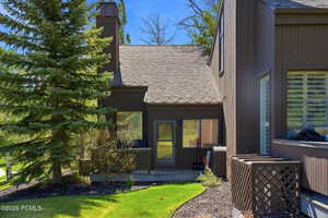 Brown exterior siding with a shingled roof and a prominent chimney