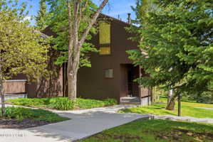 Brown-sided exterior featuring varied window placements and a covered entryway