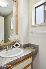 Vanity with an integrated sink and brushed nickel faucet, set within a natural stone tile countertop