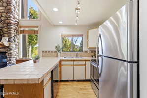 Kitchen with stainless steel appliances, including a refrigerator and range