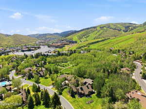 Aerial perspective showcasing a residential community nestled among lush green trees and rolling hills