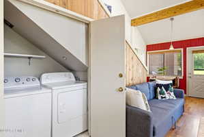 Dedicated laundry area featuring a washer and dryer beneath a sloped ceiling