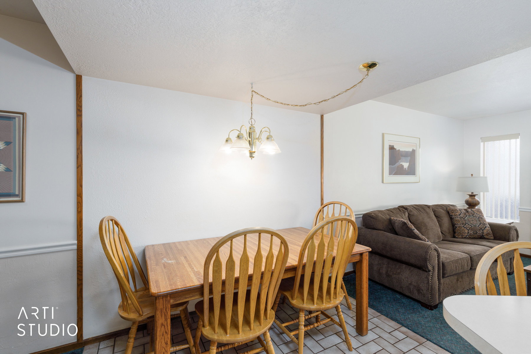 Open-concept living space featuring a dining area with a brass-finish chandelier and a patterned tile floor