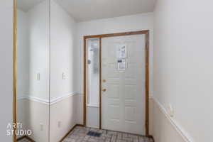 Entryway featuring a paneled door with wood-finish trim and an adjacent full-length sidelight