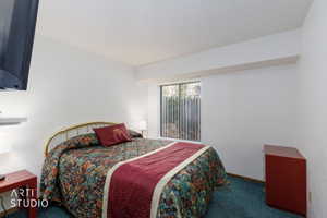 Bedroom featuring a window with vertical blinds, providing natural light
