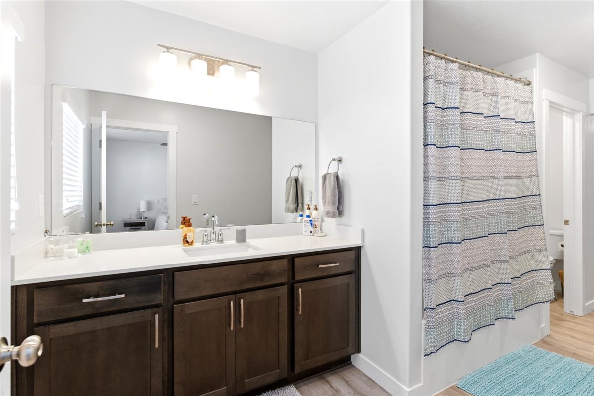 Bathroom vanity featuring a single sink, light-toned countertop, and dark wood-finish cabinetry