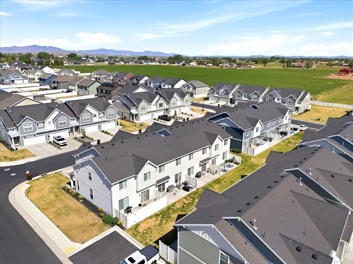 Newer construction townhomes featuring attached garages, private patios, and modern exterior finishes