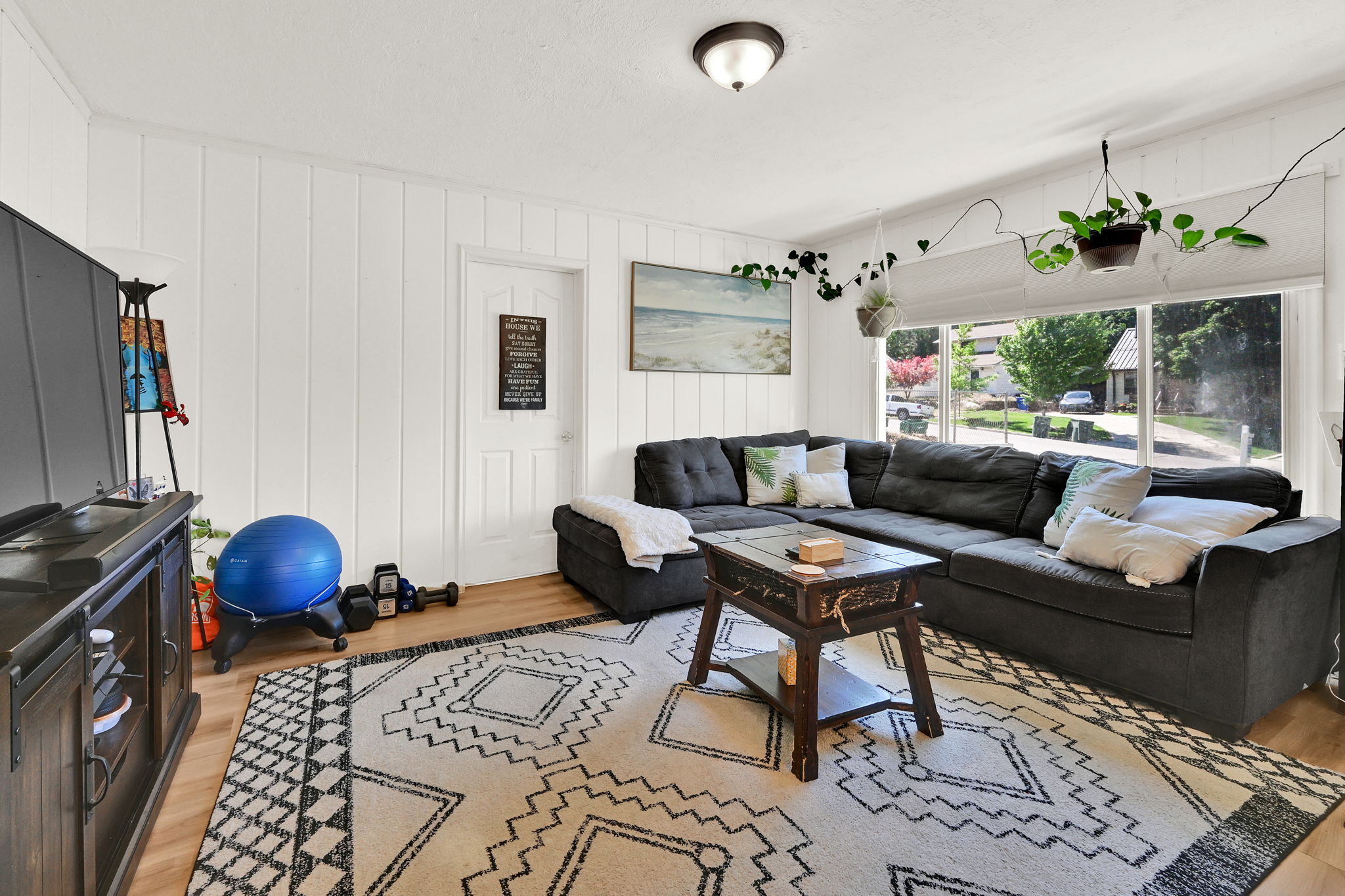 Bright interior space featuring white vertical paneling and wood-finish flooring
