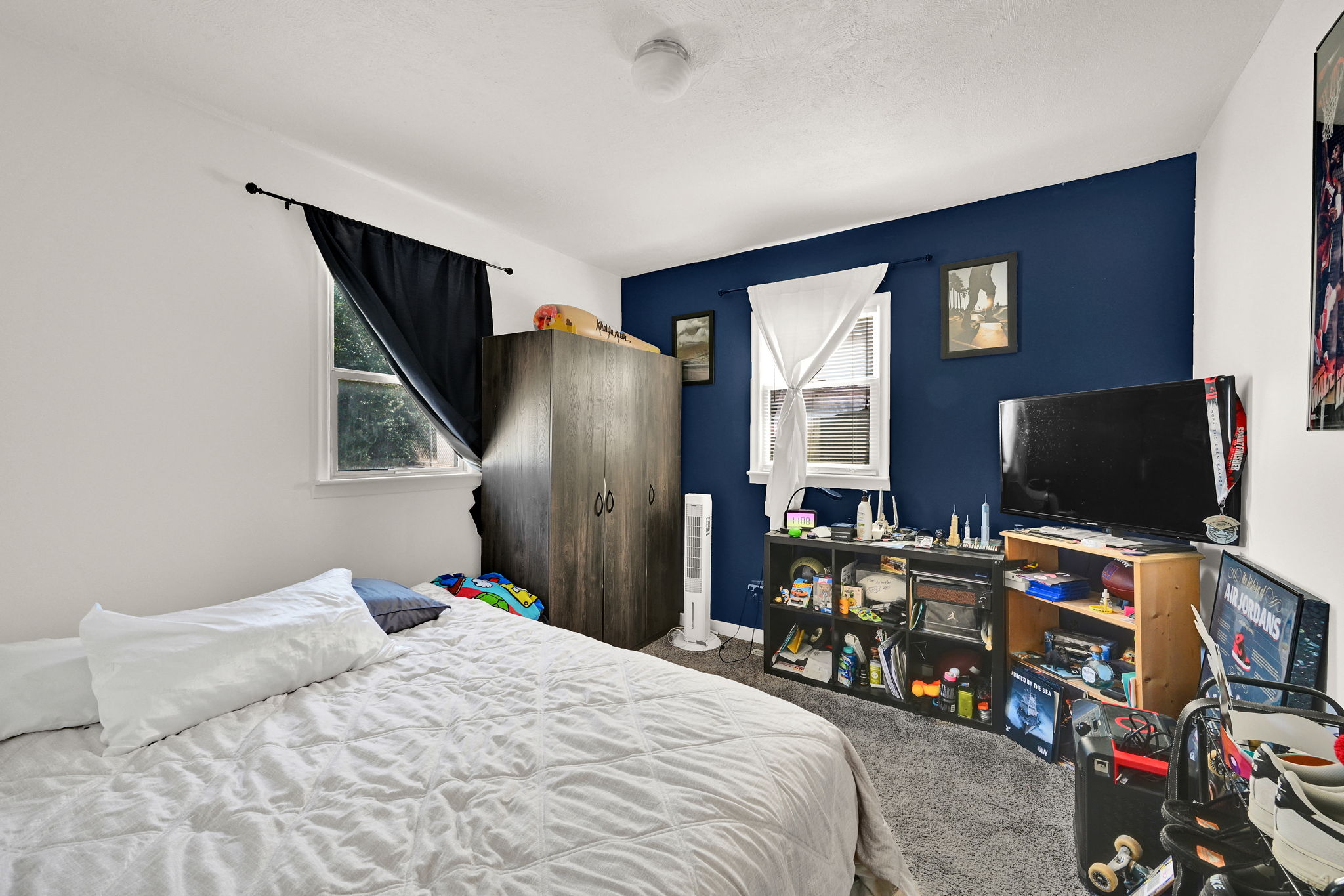 Bedroom featuring two windows, a ceiling light fixture, and a mix of white and blue painted walls