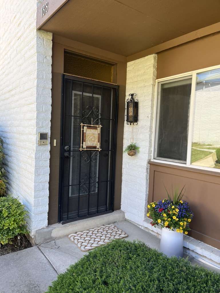 Entryway featuring white painted brick, a security screen door, and a transom window