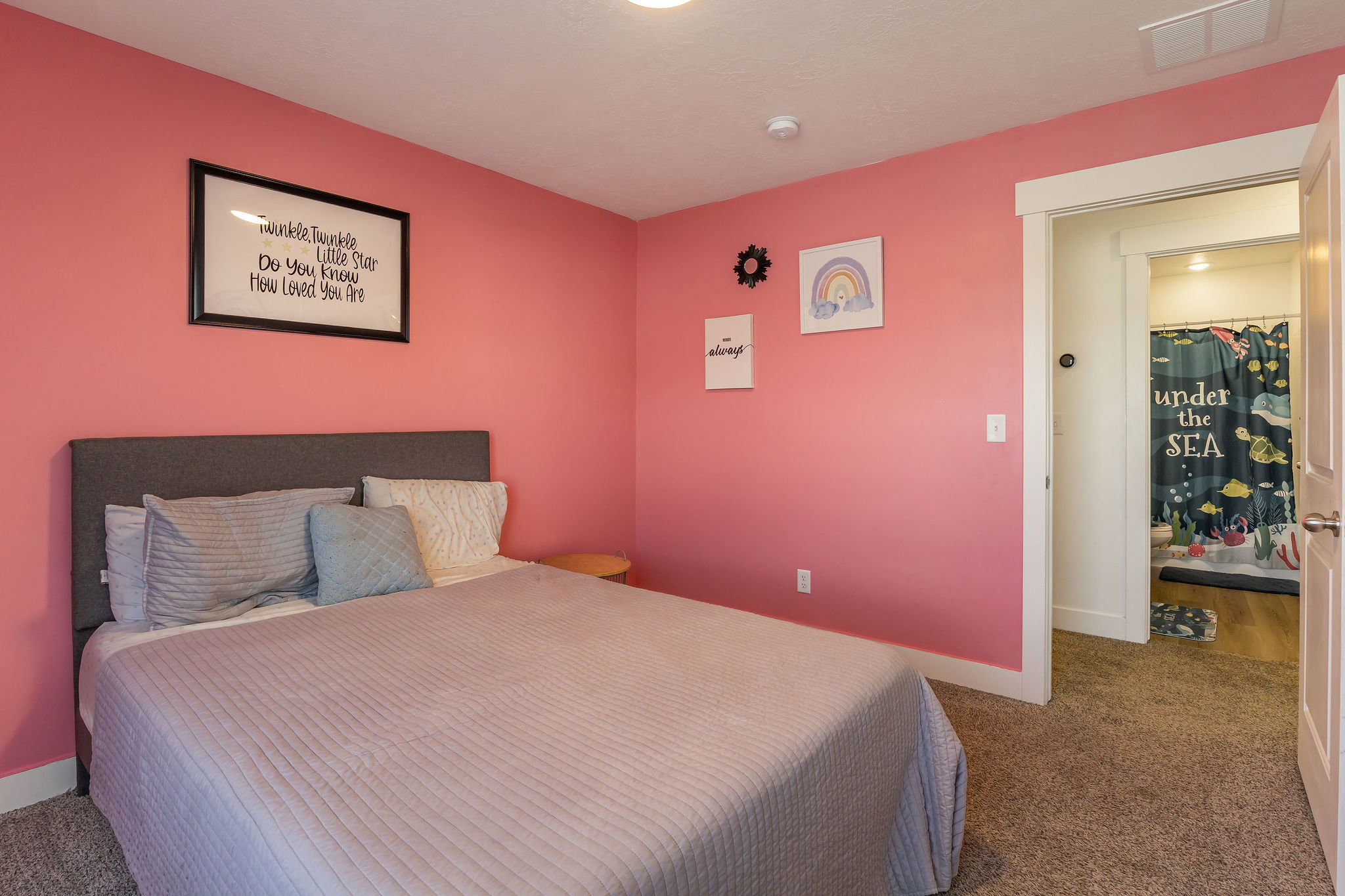 Bedroom with plush carpeting, a built-in closet with a white door, and an entryway to a full bathroom
