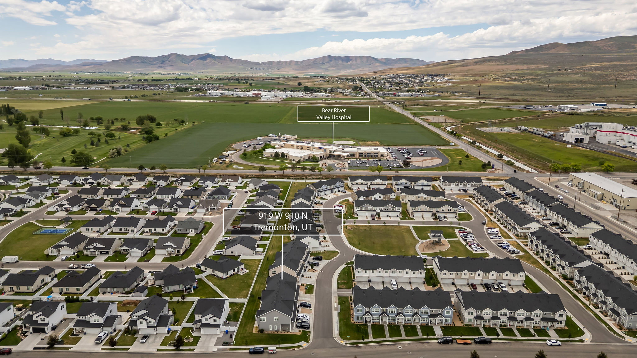 Aerial view showcasing a residential development with single-family homes and townhomes
