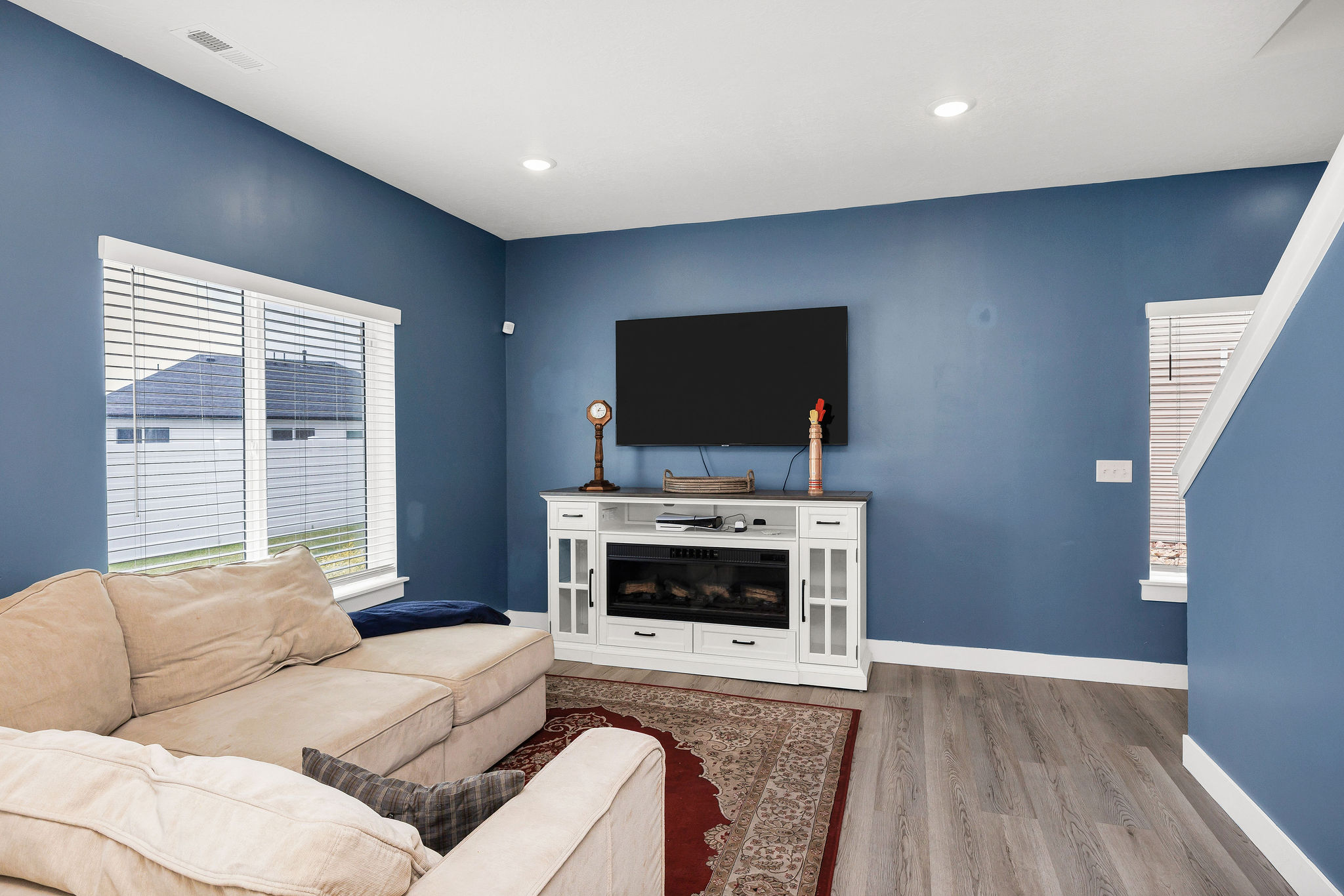 Living area featuring light wood-finish flooring and a built-in media console with an electric fireplace