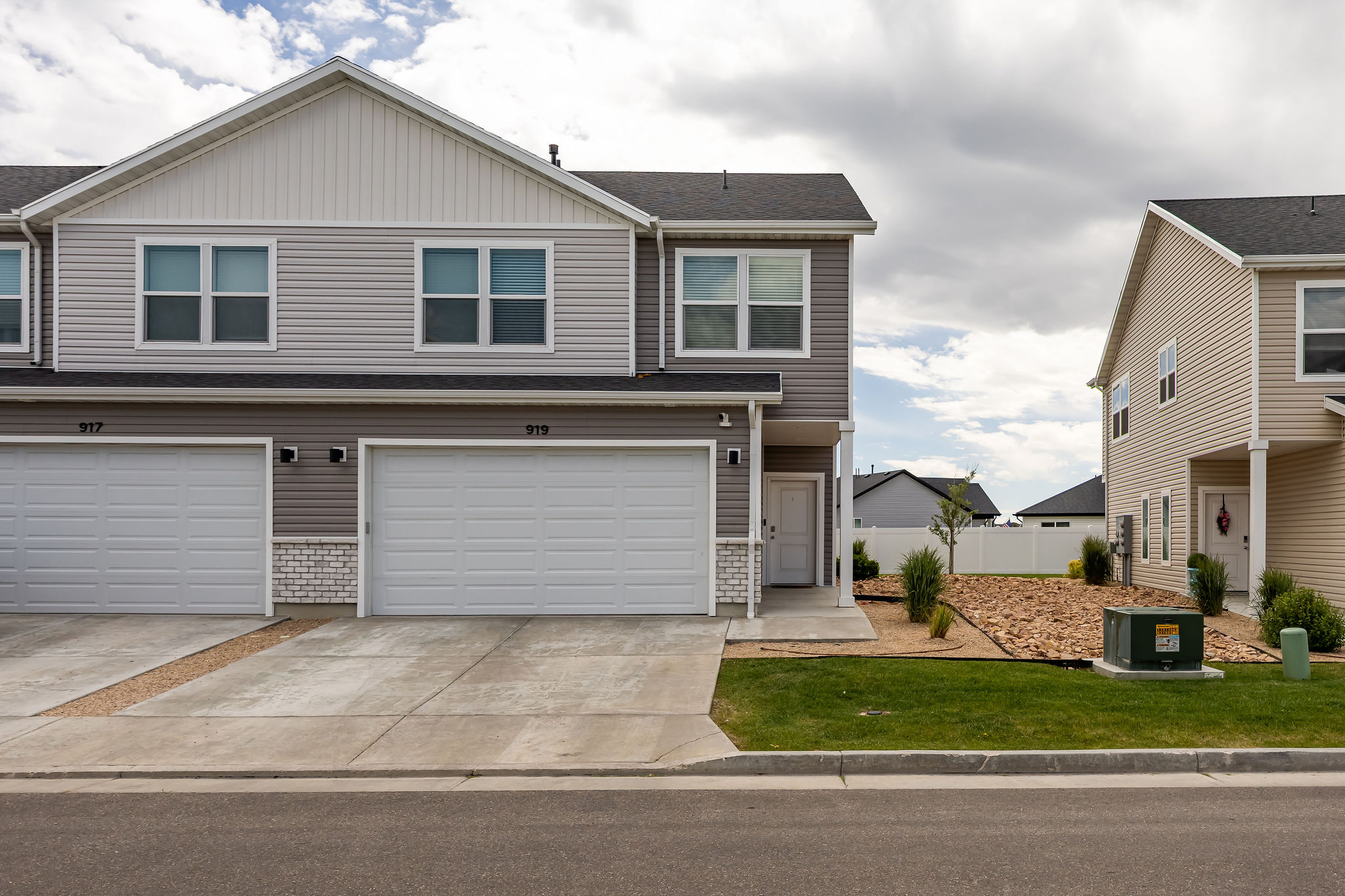 Multi-level residence featuring gray horizontal siding and white trim