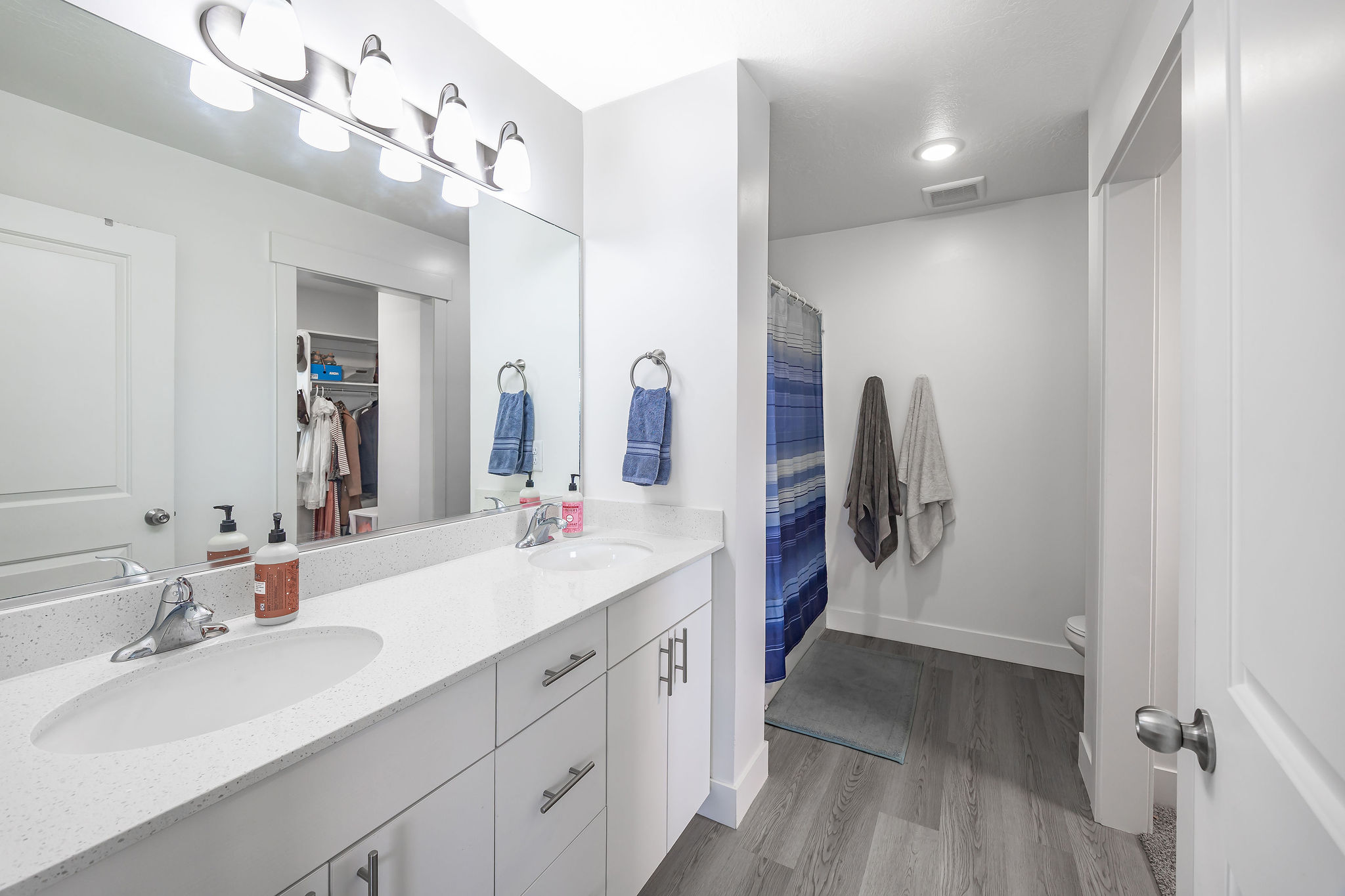 Double vanity with white cabinetry, integrated sinks, and a speckled countertop
