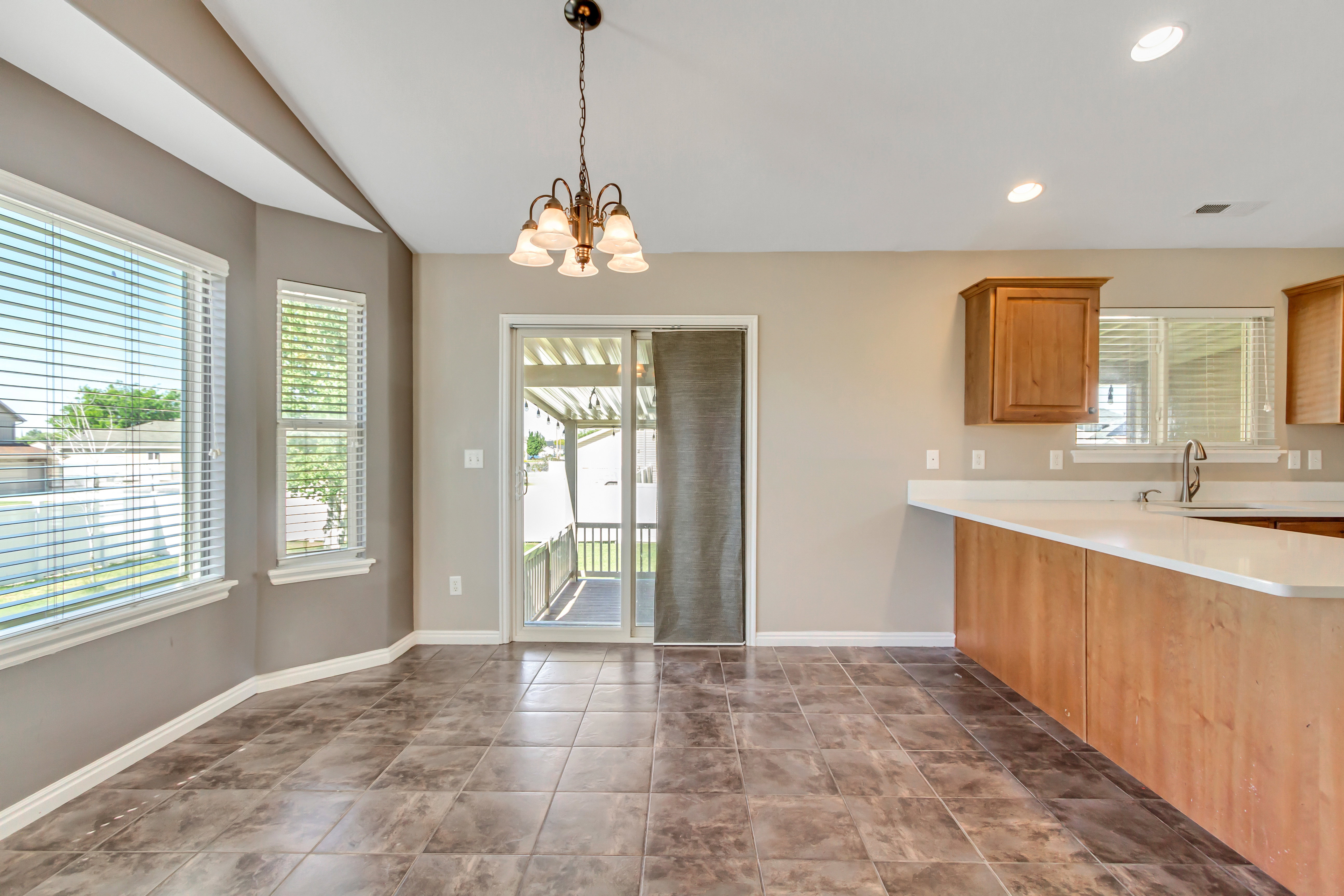 Spacious kitchen and dining area with tile flooring and a patio door