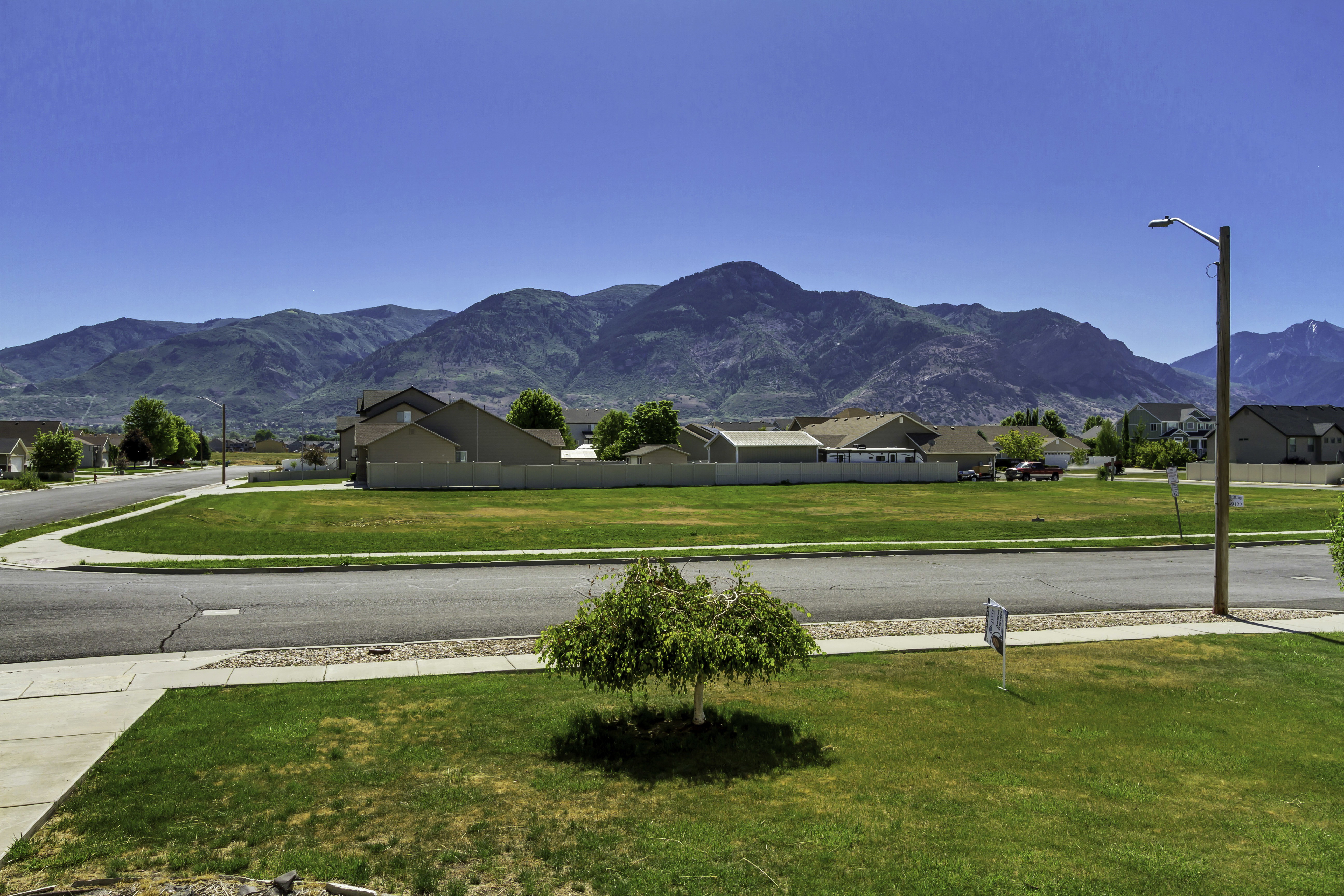 Expansive green space and paved roads framed by a distant mountain range