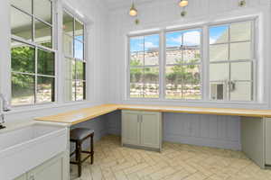 Room with an integrated farmhouse sink and chrome faucet, surrounded by built-in cabinetry