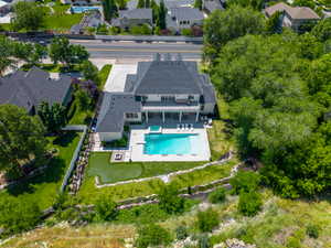 Expansive backyard featuring a rectangular swimming pool, integrated hot tub, and a putting green