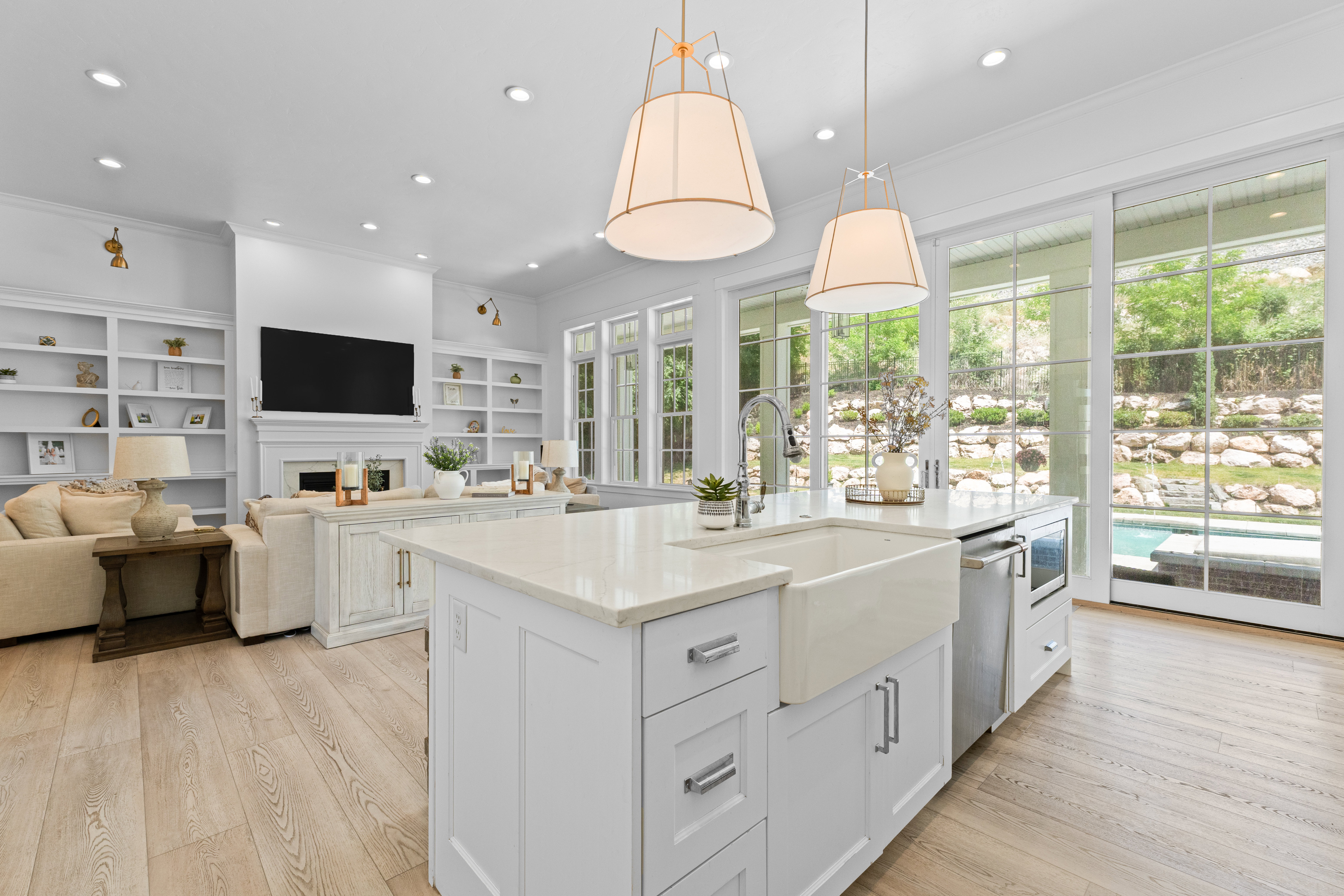 Modern kitchen island featuring a farmhouse sink, integrated dishwasher, and microwave drawer