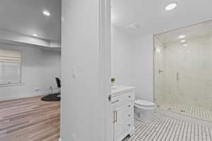 Contemporary bathroom featuring a glass-enclosed shower with large format tile, a vanity with a light-colored countertop, and a black-and-white octagon tile floor