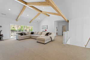 Vaulted ceiling with exposed wood beams, recessed lighting, and wall-to-wall carpeting