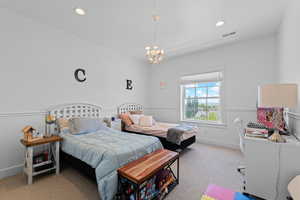 Carpeted interior room featuring a window with a white frame, overhead recessed lighting, a chandelier, and wainscoting