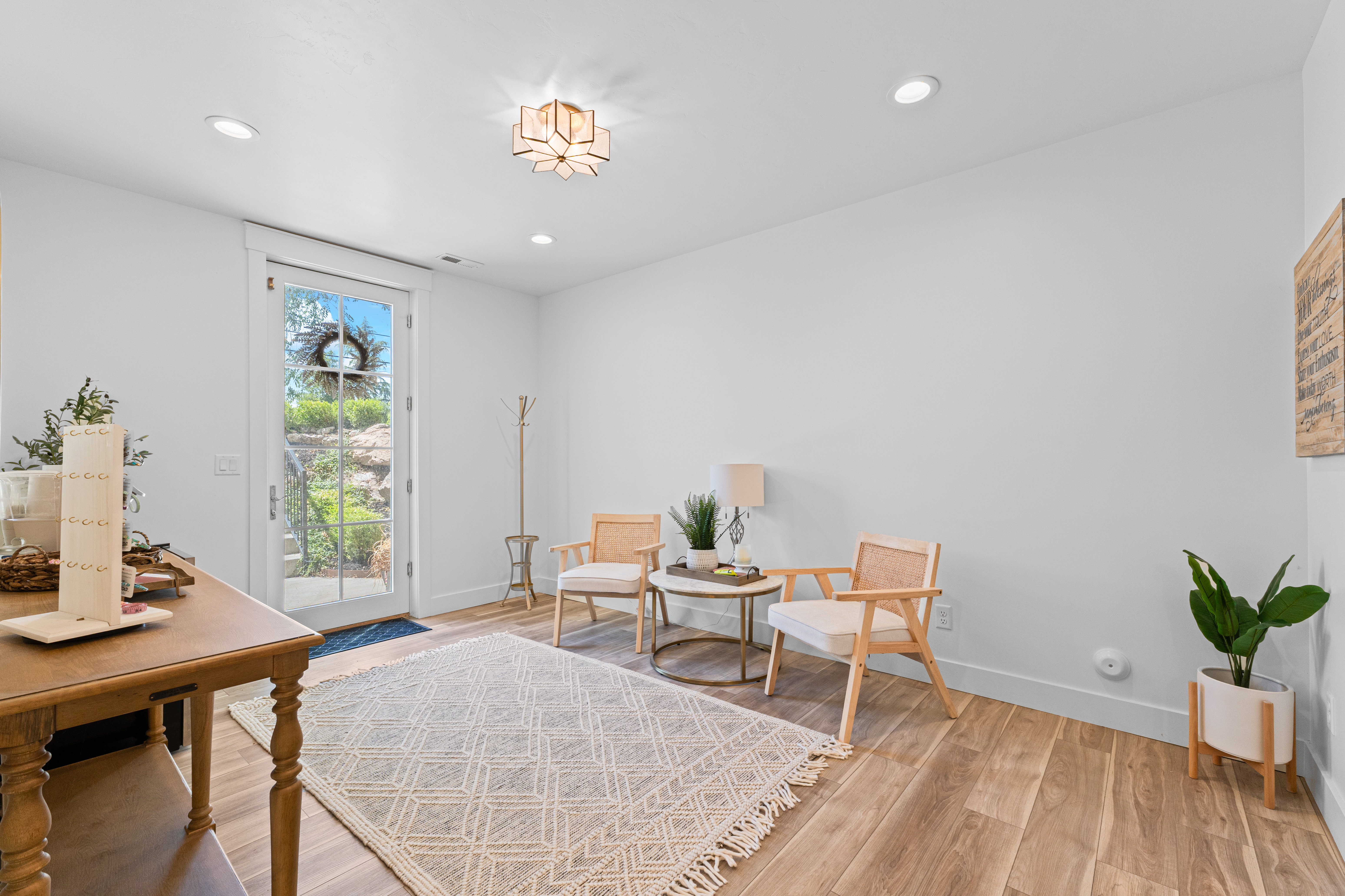 Bright interior room featuring a glass-paneled door, wood-finish flooring, recessed lighting, and a decorative ceiling fixture
